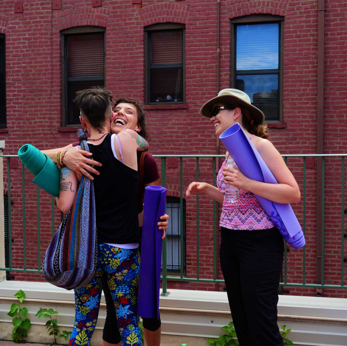 yoga students hug after a class on the roof at Smith Center
